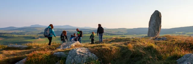 Randonnée en famille devant la Pierre Levée à proximité du massif du Lizieux