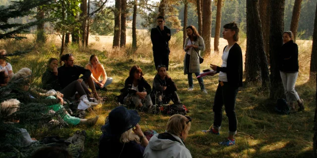 festival des Lectures sous l'arbre avec lecture de poèmes en forêt et des gens assis dans l'herbe